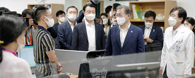 문재인
 대통령이 28일 서울 중구 국립중앙의료원 수도권 병상 공동대응 상황실을 방문해 정기현 원장(오른쪽) 등 직원들을 격려하고 있다.
 중증환자 병상 확보 현황 등을 보고받은 문 대통령은 “사회적 거리 두기를 3단계로 방역 단계를 격상하는 부분은 좀 더 신중하게 
해야 한다”고 말했다. 청와대사진기자단