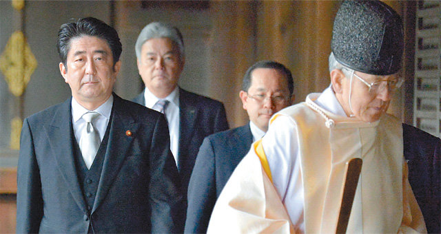 2013년 12월 야스쿠니 신사를 직접 찾은 아베 신조 일본 총리(왼쪽). 이에 대해 국제 사회의 비난이 커지자 아베 총리는 이후로는 직접 참배는 하지 않고 신사에 공물을 보냈다. 아사히신문 제공