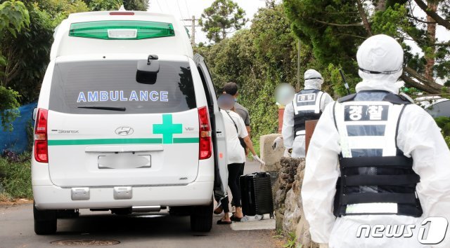 지난 28일 오후 제주 서귀포시 남원읍 태흥2리의 한 게스트하우스에서 제주 36·37번째 코로나19 확진자의 밀접 접촉자인 일부 투숙객들이 캐리어를 들고 구급차량에 탑승하고 있다. © News1