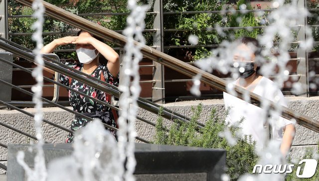 서울을 비롯해 많은 지역에 폭염특보가 발효된 24일 오후 서울 청계천에서 한 시민이 손으로 햇빛을 가리며 걷고 있다. 2020.8.24/뉴스1 © News1