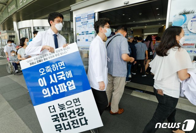 전공의들이 무기한 파업을 지속하기로 한 31일 서울 종로구 서울대병원 본관 앞에서 전문의들이 정부가 추진하고 있는 의대 정원 확대, 공공의대 설립 등을 반대하며 1인 피켓 시위를 하기위해 이동하고 있다. 2020.8.31/뉴스1 © News1