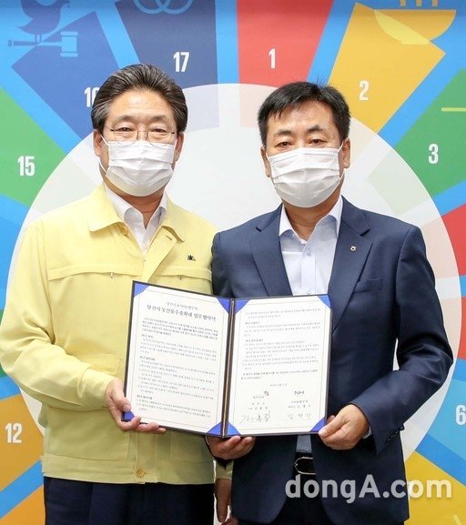 지난달 31일 충남 당진시청에서 열린 '당진시 농산물 수출확대 업무협약식'에서 김홍장 당진시장(왼쪽)과 김재기 NH농협무역 대표이사가 기념촬영을 하고 있다. 농협 제공