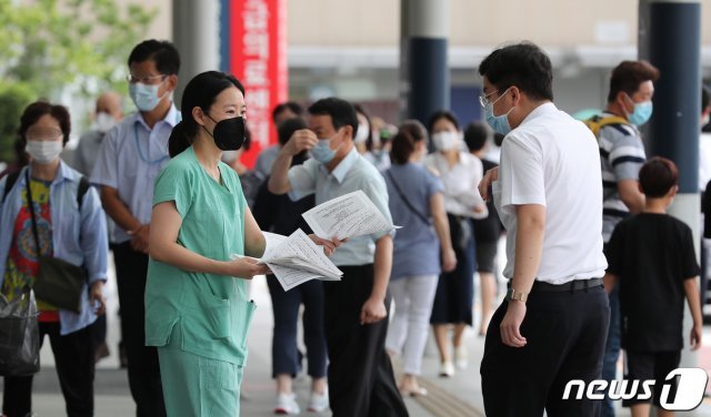 전공의·전임의 등 의료계가 의대정원 확대, 공공의대 설립 등 주요 정책 철회를 촉구하며 집단휴진을 이어가고 있다. 한 전공의가 1일 서울 종로구 서울대병원 본관 앞에서 정부가 추진하고 있는 의대 정원 확대, 공공의대 설립 반대 내용을 담은 유인물을 시민들에게 배포하고 있다.  2020.9.1/뉴스1 © News1