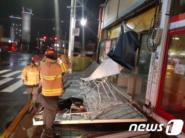 제9호 태풍 마이삭(MAYSAK)이 북상한 지난 2일 오후 6시 56분경 부산 사상구 엄궁동의 한 거리에 간판이 추락해 소방대원들이 안전조치를 하고 있다. (부산소방본부 제공) 2020.9.3/뉴스1 © News1