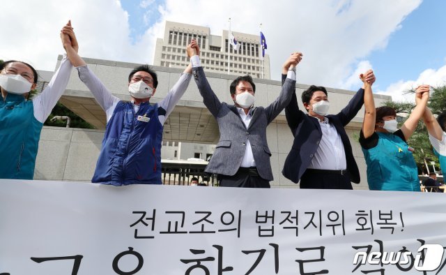 권정오 전국교직원노동조합(전교조) 위원장을 비롯한 전교조 관계자들이 3일 서울 서초구 대법원에서 열린 법외노조 통보처분 취소 소송 전원합의체 선고 공판에서 승소한 뒤 만세를 외치고 있다./뉴스1 © News1