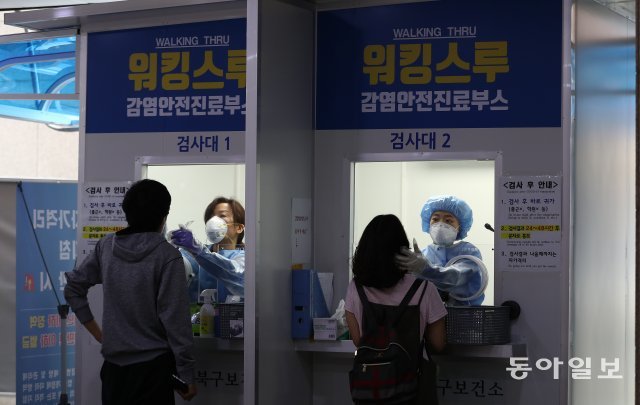 지난 8월 25일 오전 서울 성북구 보건소에 마련된 워킹스루 선별진료소에서 의료진들이 시민들의 검체를 채취하고 있다.