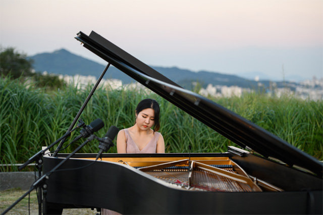 마포 6경 클래식 하늘공원편에 출연한 피아니스트 문지영이 억새밭 한가운데서 슈만의 환상곡 C장조를 연주하고 있다. 마포문화재단 제공