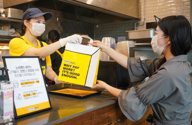 서울 성동구 성수동 노브랜드 버거 매장에서 고객이 주문한 음식을 테이크 아웃하고 있다.(신세계푸드 제공)© 뉴스1