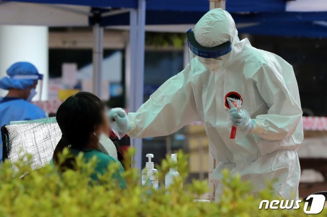 광주 북구 한 교회 주차장에 설치된 선별진료소에서 지난 6일 북구보건소 직원들이 교회 신자 등 자가격리자를 대상으로 검체를 채취하고 있다. /뉴스1 © News1