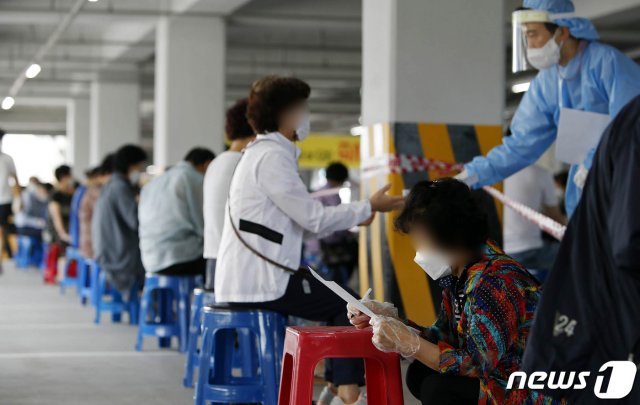 신종 코로나바이러스 감염증(코로나19) 선별진료소에서 시민들이 코로나19 검사를 받기 위해 문진표를 작성하고 있다. /뉴스1