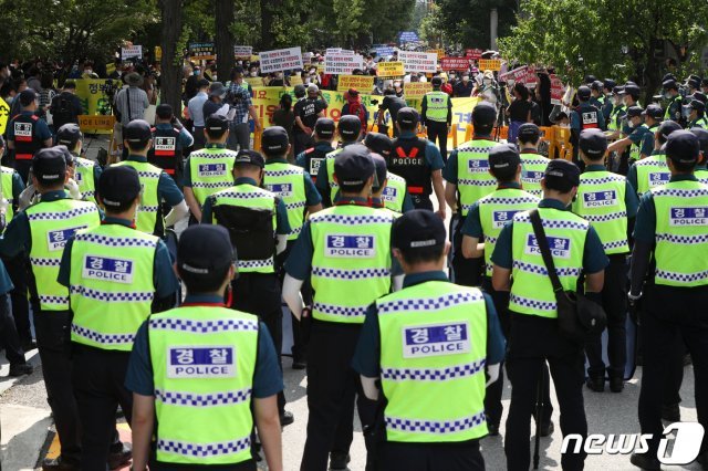 한국유흥음식중앙회 회원과 유흥주점 관계자 등 참석자들이 14일 오전 서울 여의도 국회 앞에서 열린 ‘유흥주점 2차 재난지원금 제외 규탄 기자회견’에서 경찰들과 대치하고 있다. 2020.9.14 © News1