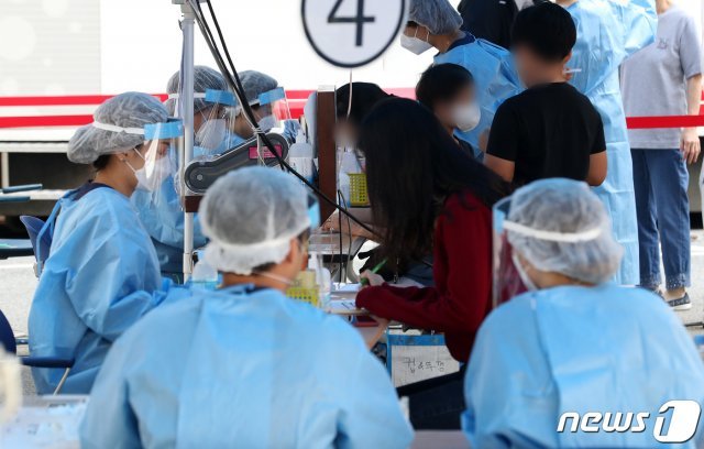 15일 오전 서울 강남구 보건소에 마련된 선별진료소에서 의료진이 학부모와 아이들의 문진표를 확인하고 있다./뉴스1 © News1