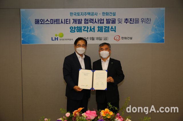 한국토지주택공사(사장 변창흠)는 18일 서울 한화건설 본사에서 ‘해외스마트시티 개발 협력사업 발굴 및 추진을 위한 양해각서’를 
체결했다. 체결식에서 이정관 LH 글로벌사업처장(오른쪽)과 김효진 한화건설 부사장이 기념촬영을 하고 있다. LH 제공
