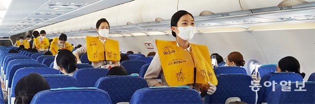 18일 에어부산이 국내 최초로 실시한 ‘목적지 없는 비행기’ 안에서 부산여대 항공관광학과 학생들이 구명조끼 착용법 
안내 실습을 하고 있다. 이날 에어부산 현직 객실 승무원 7명이 함께 탑승해 실습을 지도했다. 부산=변종국 기자 
bjk@donga.com