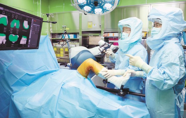 남창현 목동힘찬병원 원장(왼쪽)과 유순용 원장이 로봇 인공관절 수술에 들어가기 전 환자의 사전 3D정보를 통해 수술계획을 확인하며 의논하고 있다. 목동힘찬병원 제공