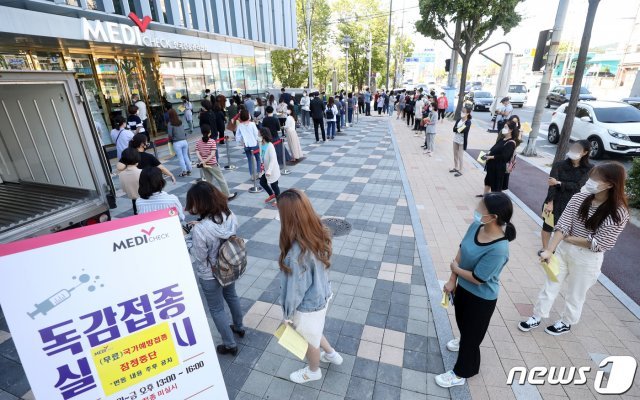 신종 코로나바이러스 감염증(코로나19) 장기화 속 쌀쌀해진 날씨로 독감이 유행하는 ‘트윈데믹’이 우려되는 가운데 무료 예방접종이 전면 중단된 22일 오후 경기도 수원시 장안구 한국건강관리협회 경기지부에서 일반 예방접종을 받기 위한 시민들이 거리두고 줄 서 있다. 2020.9.22/뉴스1 © News1