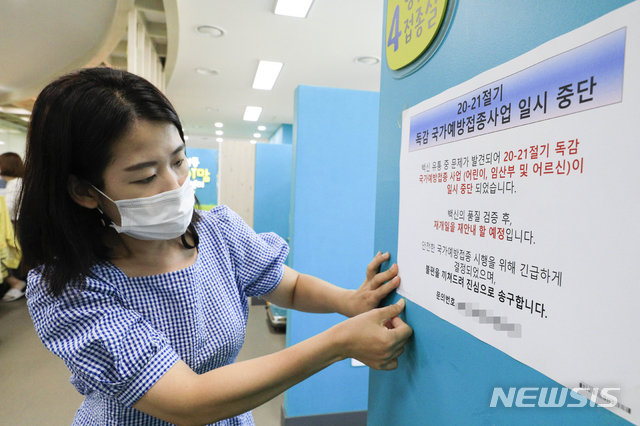 성동구보건소 직원이 22일 오전 서울 성동구 성동구보건소 예방접종실에서 무료 예방 접종 계획을 일시 중단한다는 내용의 안내문을 부착하고 있다. 출처= 뉴시스