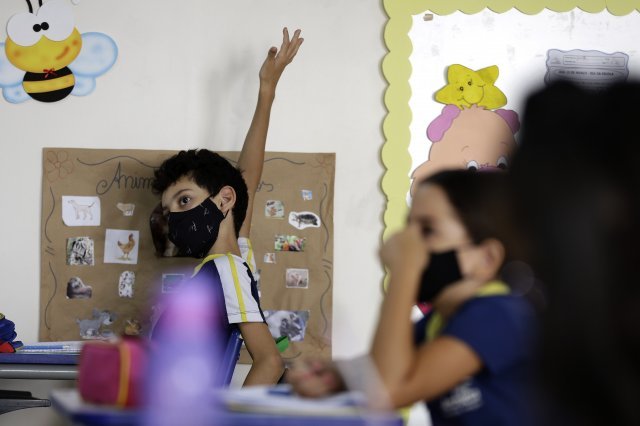 지난 21일 개학한 브라질의 한 사립학교에서 어린이가 손을 들고 선생님 질문에 답하려고 합니다. AP 뉴시스