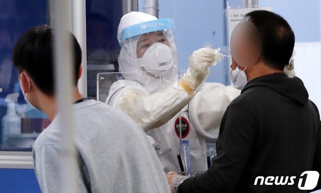 18일 서울 송파구 선별진료소에서 한 시민이 신종 코로나바이러스 감염증(코로나19) 검체 검사를 받고 있다. © News1