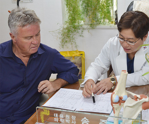 거스 히딩크 전 한국 축구대표팀 감독(왼쪽)이 송준섭 강남제이에스병원 원장에게 진료를 받고 있다. 강남제이에스병원 제공