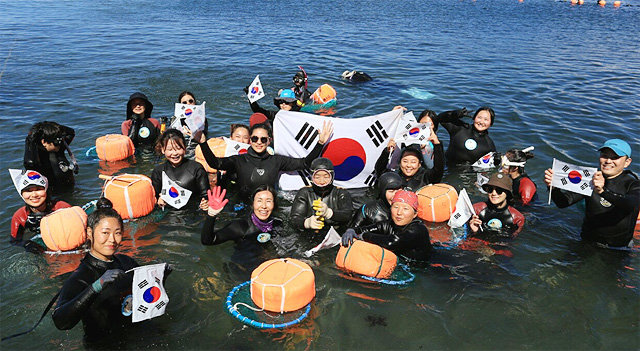 제주시 한림읍 귀덕2리 한수풀해녀학교의 해녀 강사와 학생들이 8월 15일 수업 중에 태극기를 들고 광복절 퍼포먼스를 펼치고 있다. 올해 13기 입문반과 4기 직업해녀 양성반 교육을 마친 한수풀해녀학교 졸업생 중에는 50여 명이 실제 제주도에서 해녀로 활동하고 있다. 한수풀해녀학교 제공