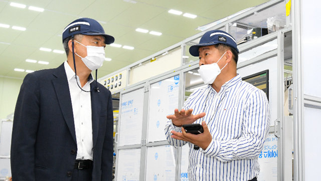 이인호 K-SURE 사장(왼쪽)이 올해 5월 27일 충북 청주시에 있는 신산업인 2차전지 생산설비 제조업체의 생산 공장을 방문해 기업 대표와 얘기를 나누고 있다.  한국무역보험공사 제공