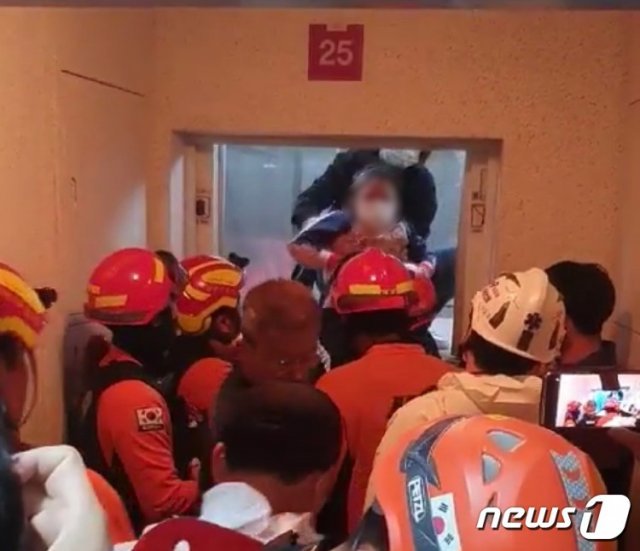 엘리베이터에 2시간 넘게 갇혀 있다가 구조되고 있는 모녀 모습.(부산경찰청 제공) /© 뉴스1
