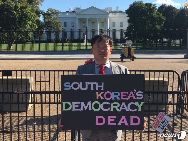 민경욱 전 국민의힘 의원이 지난 2일 자신의 페이스북에 미국 백악관앞에서 ‘한국의 민주주의는 죽었다’며 부정선거를 규탄하는 피켓시위를 펼치는 모습을 소개했다. (페이스북 갈무리) © 뉴스1