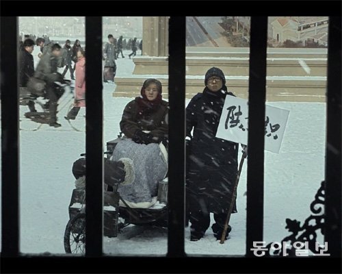 영화 ‘5일의 마중’에서 기억을 잃은 펑안위(왼쪽)는 남편이 바로 옆에 있지만 알아보지 못하고, 매월 5일이 오면 기차역에 나가 남편을 애타게 기다린다. 동아일보DB