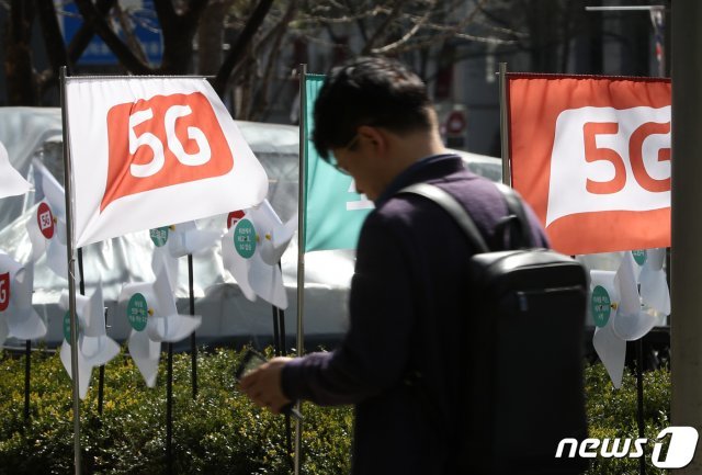 8일 오후 서울 시내의 한 휴대폰 전시장 인근에 5G 상용화를 알리는 깃발이 바람에 날리고 있다… 2019.4.8/뉴스1 © News1