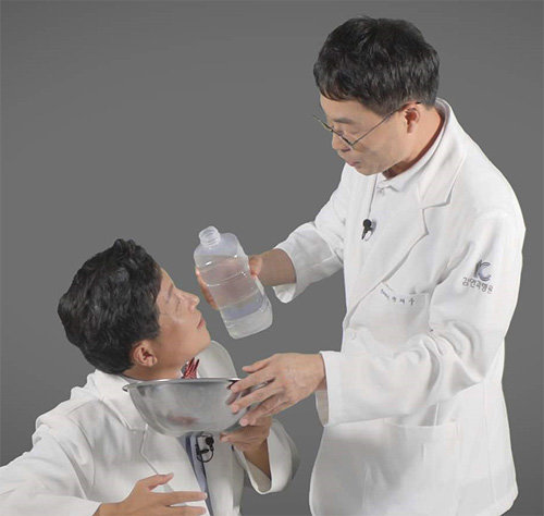 김안과병원 장재우 원장(오른쪽)이 눈에 손소독제가 들어갔을 때 응급조치하는 방법에 대해 시범을 보이고 있다. 김안과병원 제공
