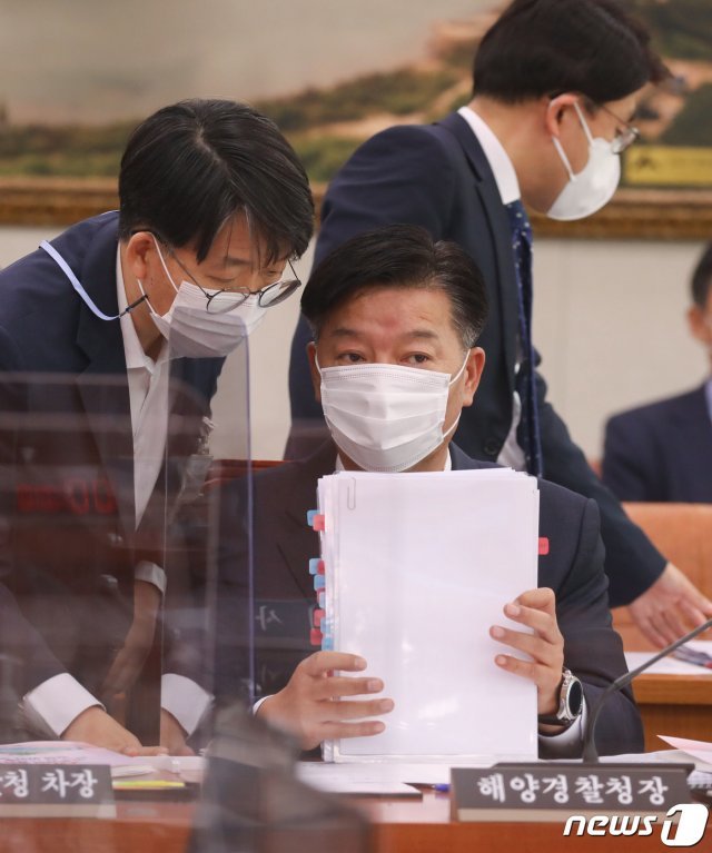 김홍희 해양경찰청장이 8일 오전 서울 여의도 국회에서 열린 농림축산식품해양수산위원회의 해양수산부에 대한 국정감사에서 관계자와 대화를 나누고 있다. 2020.10.8/뉴스1 © News1