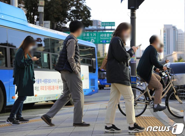 찬이슬이 맺히기 시작하는 절기 한로(寒露)인 8일 오전 서울 광화문광장에서 출근하는 직장인들이 길을 건너고 있다.2020.10.8 © News1