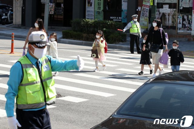 서울의 한 초등학교 인근에서 경찰과 교통안전 자원봉사원들이 등교 지도를 하고 있다.2020.5.27/뉴스1 © News1