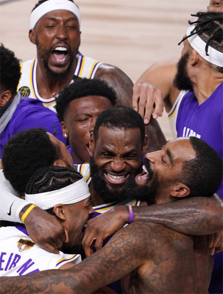 LA 레이커스의 르브론 제임스(가운데)가 12일 열린 2019∼2020 미국프로농구(NBA) 챔피언결정전(7전 4승제) 6차전에서 마이애미를 꺾고 우승을 확정한 뒤 동료들을 껴안고 감격해 하고 있다. 올랜도=AP 뉴시스