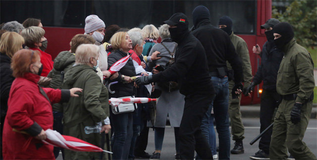 사복경찰과 맞닥뜨린 할머니 시위대 12일 벨라루스 수도 민스크에서 ‘할머니들은 시위대 편’이라고 쓴 푯말과 꽃을 들고
 대통령 퇴진 요구 시위에 참여한 여성 노인들이 경찰관과 충돌하고 있다. 벨라루스 정부는 앞으로 총기류 등 치명적인 무기를 사용해
 시위대를 진압하겠다고 예고해 유혈사태가 우려된다. 민스크=AP 뉴시스