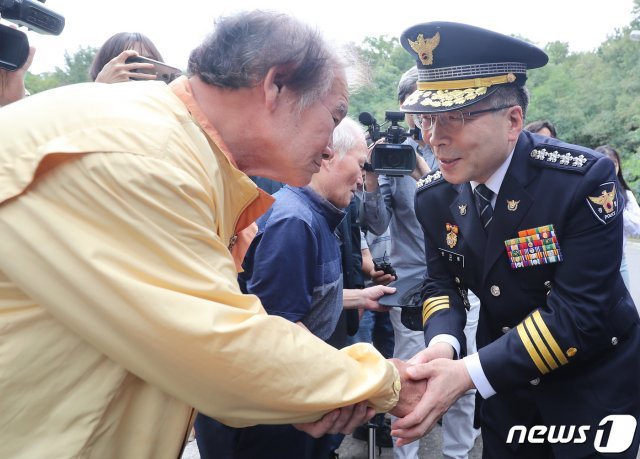 지난해 9월 당시 민갑룡 경찰청장이 대구 달서구 와룡산 세방골 개구리소년 유골 발견 현장 방문에 앞서 희생자 박찬인(당시 10세)군의 아버지 박건서(67)씨의 손을 잡고 위로하고 있다. 2019.9.20/뉴스1 © News1