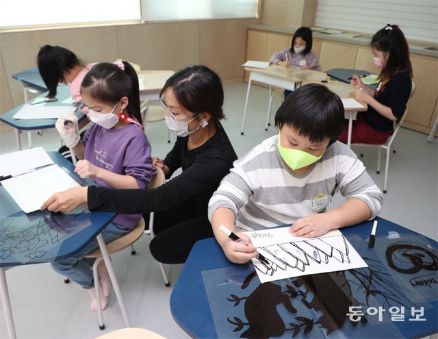 13일 오후 서울 노원구 거점형 우리동네키움센터를 찾은 초등학생들이 선생님의 지도로 OHP 필름에 그림을
그리며 사진 인화 기법을 체험하고 있다.
박영대 기자 sannae@donga.com
