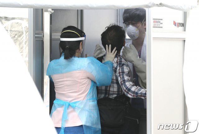 서울 중구 국립중앙의료원에 마련된 선별진료소에서 한 내원객이 코로나19 검사를 받고 있다./뉴스1