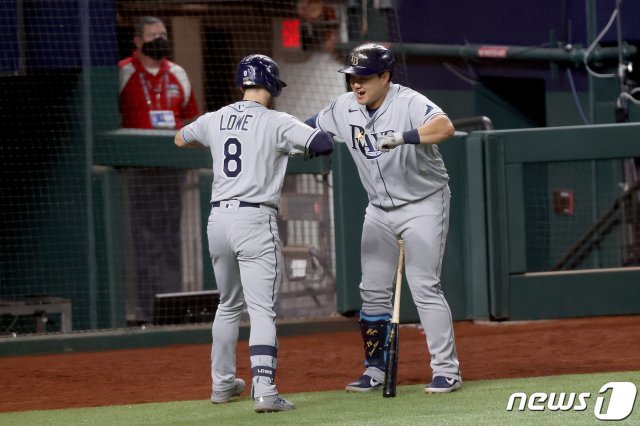 탬파베이 브랜든 로우가 월드시리즈 2차전에서 홈런을 터트린 뒤 최지만과 세리머니를 하고 있다. © AFP=뉴스1