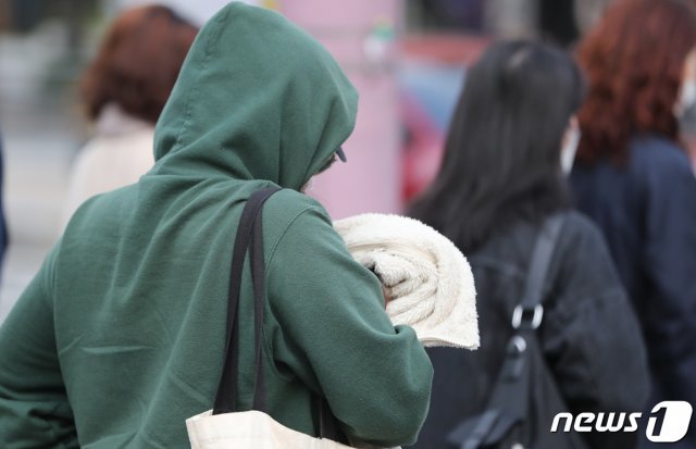 아침 기온이 10도 선을 맴도는 쌀쌀한 날씨를 보인 12일 서울 광화문사거리에서 두툼한 옷차림의 한 시민이 발걸음을 재촉하고 있다. 2020.10.12 © News1