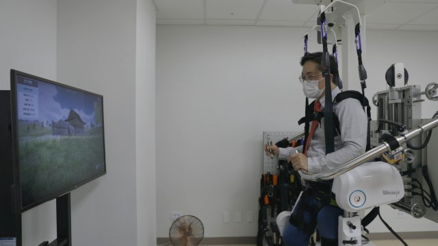 본보 이진한 의학전문기자가 국민건강보험공단 일산병원이 도입한 보행재활로봇 ‘워크봇’을 착용해 체험하고 있다. 동영상 캡처