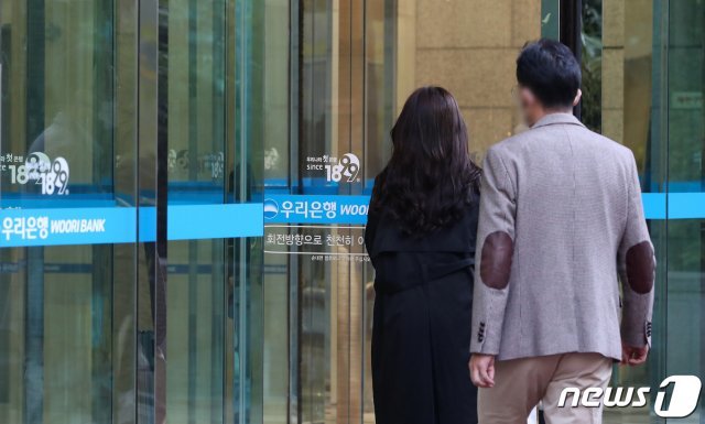 서울 중구 우리은행 본점에 직원들이 출근하고 있다. 우리은행 측은 “임원 5명이 신종 코로나바이러스 감염증(코로나19) 확진 판정을 받았다”고 지난 25일 밝혔다. /뉴스1 © News1