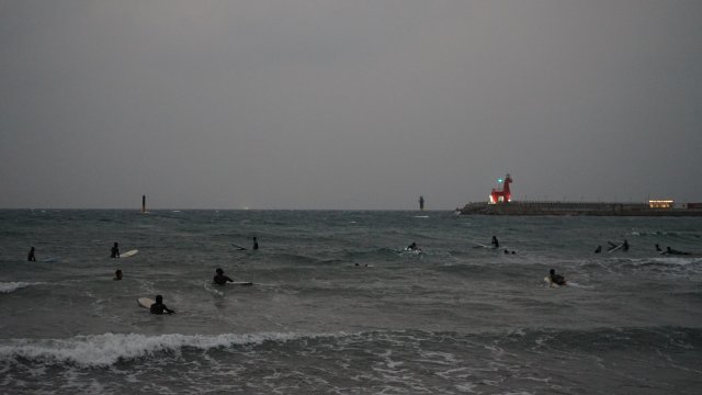 서핑하기 좋은 해변으로 알려진 이호테우해변에서 해가 졌지만 많은 사람들이 서핑을 즐기고 있다.