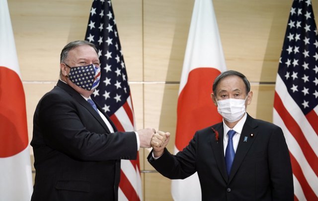 스가 요시히데 일본 총리(오른쪽)와 마이크 폼페이오 미국 국무장관이 10월 6일 일본 도쿄에서 만나 주먹 인사를 하고 있다. [도쿄=AP 뉴시스]