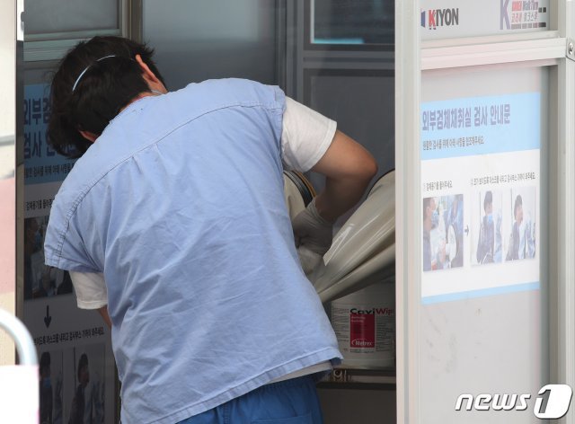 지난달 28일 서울 중구 국립중앙의료원에 마련된 선별진료소에서 의료진들이 검체채취 장비를 소독하고 있다./뉴스1 © News1