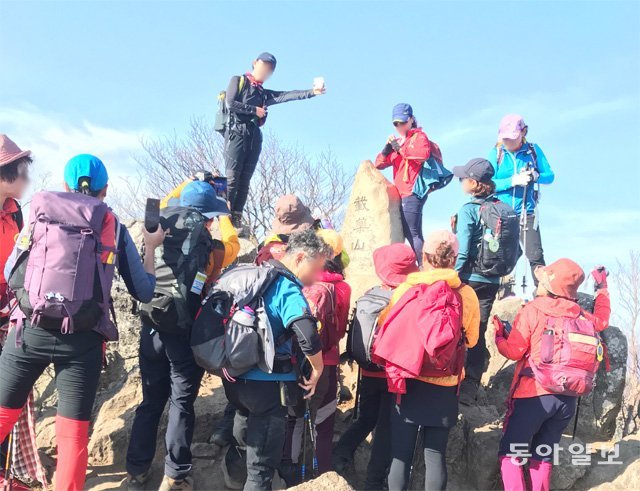 지난달 31일 경남 밀양시 재약산 정상에 등산객들이 ‘인증샷’을 찍기 위해 대기하고 있다. 울산 울주군이 펼치고 있는 ‘영남알프스’ 9봉 완등 사업에 참가하는 등산객들로 산 정상이 북적이고 있다. 정재락 기자  raks@donga.com