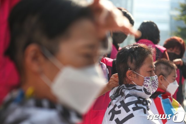 지난달 27일 서울 영등포구 여의도 더불어민주당 중앙당사 앞에서 전국학교비정규직노동조합 돌봄전담사들이 기자회견을 열고 돌봄시간제 폐지와 초등돌봄교실 법제화를 촉구하며 삭발식을 하고 있다./뉴스1 © News1