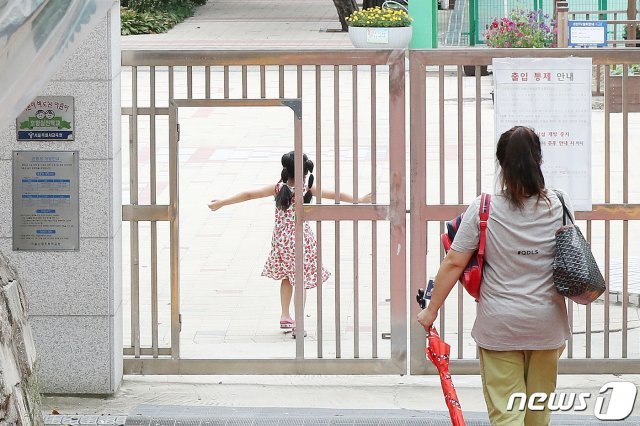 서울 한 초등학교에서 학부모가 자녀를 오후 돌봄교실에 바래다주고 있다. 2020.9.16 © News1