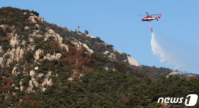 10월 30일 서울 은평구 북한산 족두리봉 인근 등산로에서 화재가 발생해 소방헬기가 진화작업을 벌이고 있다. 2020.10.30/뉴스1 © News1